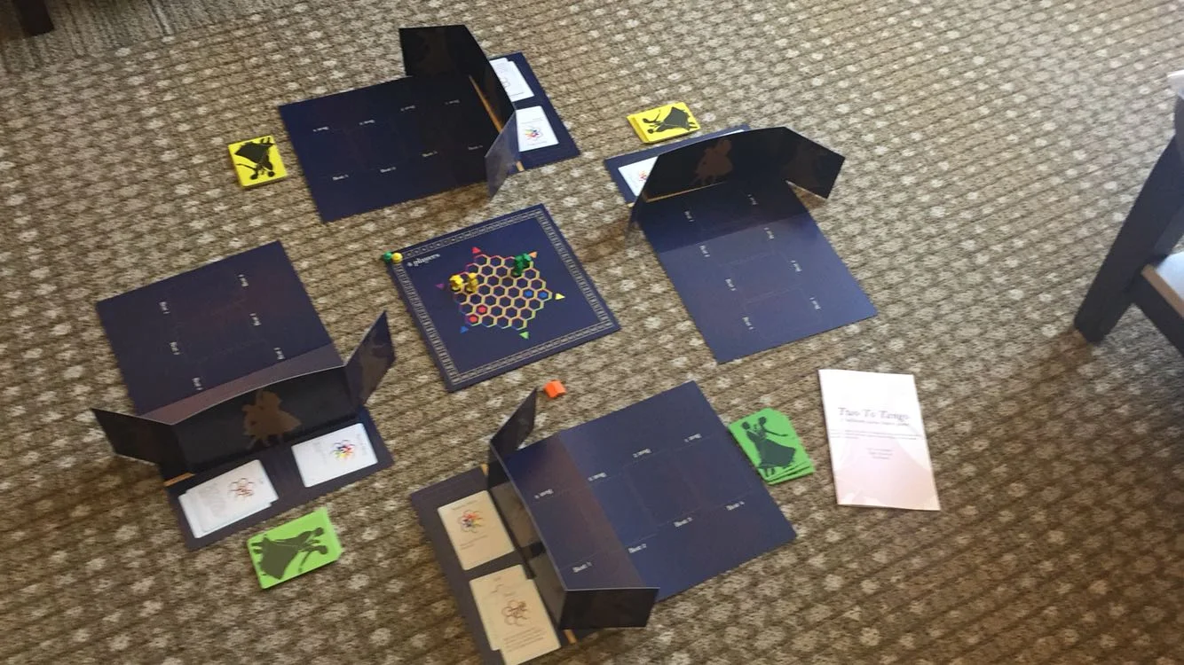 Full Two To Tango prototype setup on the floor, showing four player boards, dance move cards, and the central hex tracking board